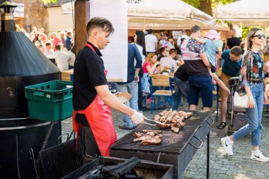 UKRAINE, LUTSK - 5 Haziran 2019: Adam yemek festivalinde et pişiriyor.