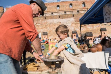 UKRAINE, LUTSK - 5 Haziran 2019: Çömlekçiliğe çömlek yapmayı öğreten yetişkin bir adamın elleri.