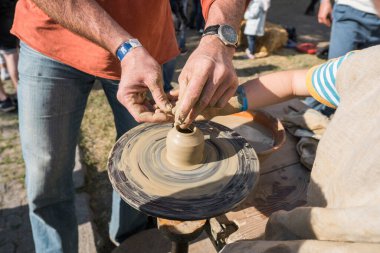 UKRAINE, LUTSK - 5 Haziran 2019: Çömlekçiliğe çömlek yapmayı öğreten yetişkin bir adamın elleri.