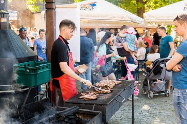 UKRAINE, LUTSK - 5 Haziran 2019: Adam yemek festivalinde et pişiriyor.