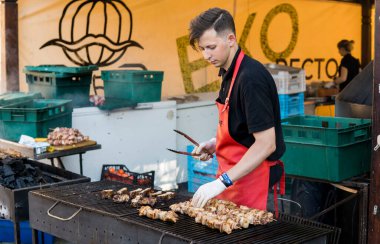 UKRAINE, LUTSK - 5 Haziran 2019: Adam yemek festivalinde et pişiriyor.
