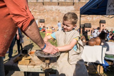 UKRAINE, LUTSK - 5 Haziran 2019: Çömlekçiliğe çömlek yapmayı öğreten yetişkin bir adamın elleri.