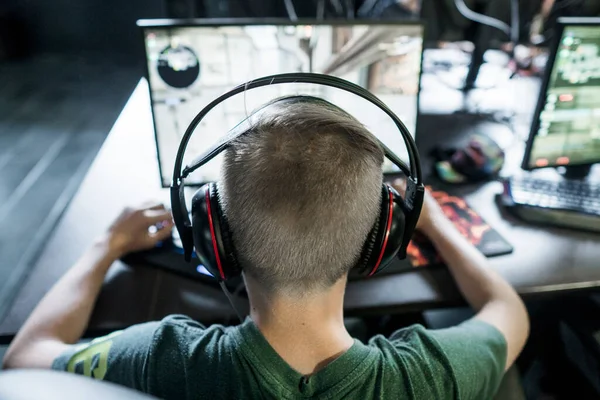 POLEN, WARSCHAU - 10. Juni 2020: Rückansicht eines jungen Spielers mit Kopfhörer beim Videospiel im Computerclub. — Stockfoto