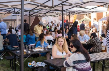 UKRAINE, LUTSK - 20 Haziran 2019: İnsanlar yemeklerini açık havada yiyorlar.