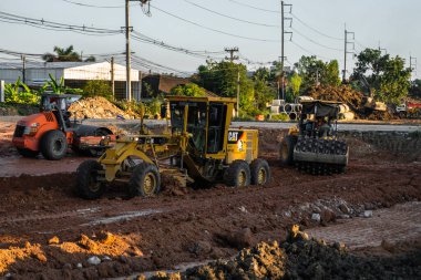 VİETNAM, HO CHI MINH - 15 Mayıs 2019: Grader yol inşaatında çalışıyor. Sınıf endüstriyel makine yeni yollar inşa ediyor. Otoyolda çalışan ağır iş makineleri.