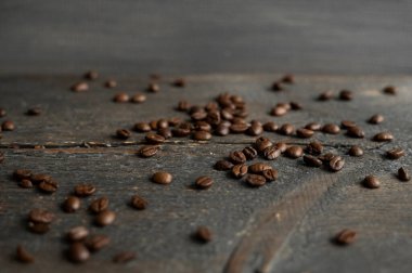 Ahşap bir masaya saçılmış kavrulmuş Arap kahve çekirdekleri. Taze kahve çekirdekleri.