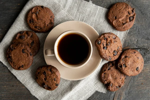 Coffee cup with cookies on wooden table background. Mug of black coffee with chocolate cookies. Fresh coffee beans. — Stock Photo, Image