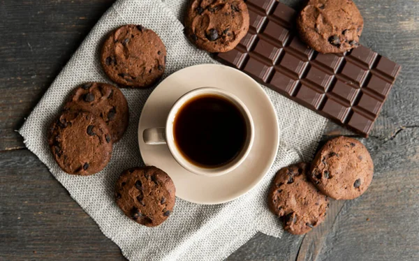 커피 컵에 쿠키와 초콜릿을 나무로 된 탁자 위에 올려 놓는다. 초콜릿 쿠키와 블랙 커피 한 조각. 신선 한 커피 콩. — 스톡 사진