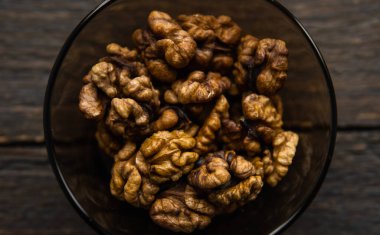 Vintage ahşap bir masada küçük bir tabakta ceviz. Ceviz sağlıklı bir vejetaryen protein besleyici gıdadır. Doğal çerezler.