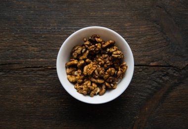 Vintage ahşap bir masada küçük bir tabakta ceviz. Ceviz sağlıklı bir vejetaryen protein besleyici gıdadır. Doğal çerezler.