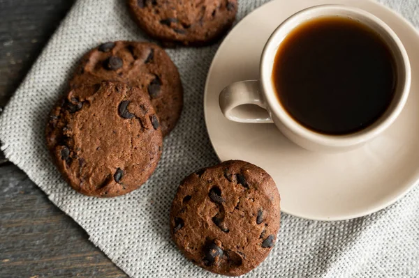 Coffee cup with cookies and chocolate on wooden table background. Mug of black coffee with chocolate cookies. Fresh coffee beans. — Stock Photo, Image