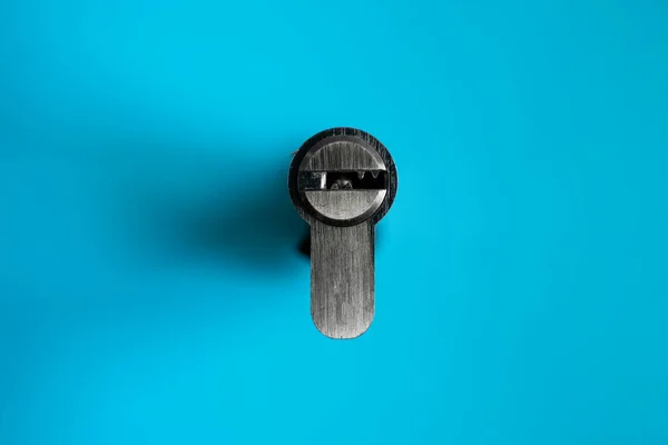 Un noyau de cylindre de serrure de porte sur le fond bleu. Le cylindre de la serrure. Installation d'une nouvelle serrure sur la porte. Pièces de rechange pour la porte. — Photo