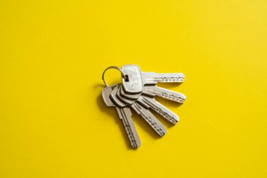 Kapı anahtarı sarı arka planda yatıyor. Anahtarlar. Bir sürü anahtar. Evin anahtarı. Yeni ev konsepti. Kiralama ve Satma.