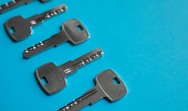 La llave de la puerta está sobre fondo azul. Conjunto de llaves. Un montón de llaves. Llave. Nuevo concepto de casa. Alquiler y venta. —  Fotos de Stock