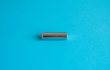 Mavi arka planda şarj edilebilir tek bir pil. Farklı cihazlar için gümüş alkali AA batarya. Enerji.