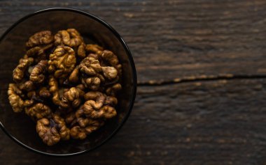 Vintage ahşap bir masada küçük bir tabakta ceviz. Ceviz sağlıklı bir vejetaryen protein besleyici gıdadır. Doğal çerezler.