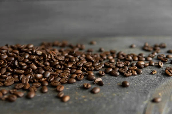 Смажені арабіки кавові зерна розкидані на дерев'яному столі. Свіжі кавові зерна . — стокове фото