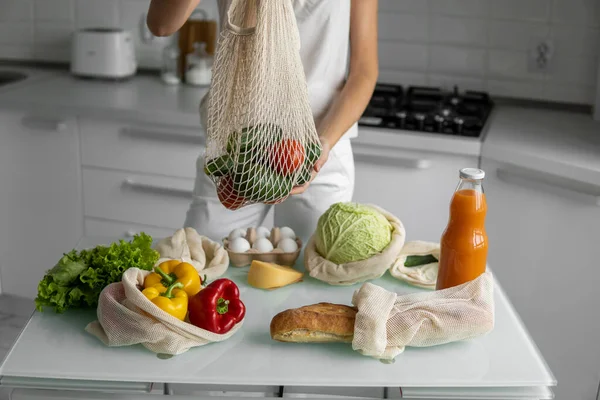 Mano de mujer sosteniendo bolsa de comestibles reutilizable con verduras y frutas. Cero residuos y concepto libre de plástico. Chica está sosteniendo malla de algodón shopper con verduras. Ecología. — Foto de Stock