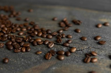 Ahşap bir masaya saçılmış kavrulmuş Arap kahve çekirdekleri. Taze kahve çekirdekleri.