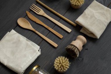 Sıfır atık. Çevre dostu bambu çatal bıçak takımı ve temizlik fırçaları, pamuk torbaları ve cam kavanozlar. Plastiksiz. Ahşap masa yüzeyinde doğal ve yeniden kullanılabilir öğeler aksesuarlar.