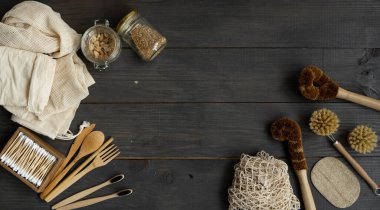 Sıfır atık. Çevre dostu bambu çatal bıçak takımı ve temizlik fırçaları, ağ pamuğu torbaları, cam kavanozlar, lif lifleri, bambu diş fırçaları ve bir kutu pamuklu çubuk. Doğal ve yeniden kullanılabilir ögeler aksesuarları.