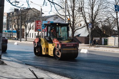 KYIV, UKRAINE - 10 Eylül 2020: Ağır asfalt yol silindirli ağır titreşimli paten sıkıştırıcısı, bir cadde üzerindeki yol inşaatında yeni bir sıcak asfalta baskı yapıyor..