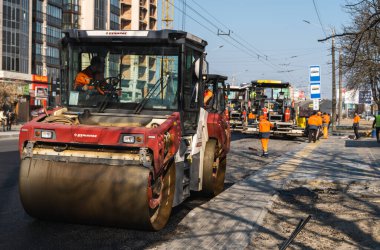 KYIV, UKRAINE - 10 Eylül 2020: Ağır asfalt yol silindirli ağır titreşimli paten sıkıştırıcısı, bir cadde üzerindeki yol inşaatında yeni bir sıcak asfalta baskı yapıyor..