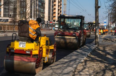 KYIV, UKRAINE - 10 Eylül 2020: Ağır asfalt yol silindirli ağır titreşimli paten sıkıştırıcısı, bir cadde üzerindeki yol inşaatında yeni bir sıcak asfalta baskı yapıyor..