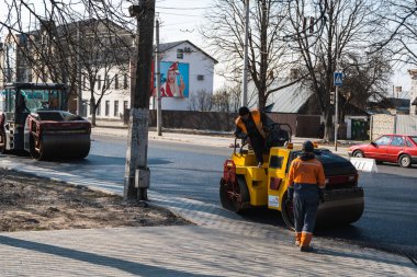 KYIV, UKRAINE - 10 Eylül 2020: Ağır asfalt yol silindirli ağır titreşimli paten sıkıştırıcısı, bir cadde üzerindeki yol inşaatında yeni bir sıcak asfalta baskı yapıyor..