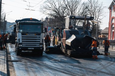 KYIV, UKRAINE - 10 Eylül 2020: Sanayi asfalt kaldırım makinesi sokaktaki yol inşaat sahasına taze asfalt seriyor.