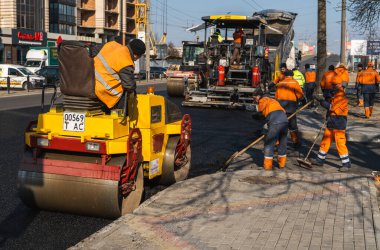 KYIV, UKRAINE - 10 Eylül 2020: Ağır asfalt yol silindirli ağır titreşimli paten sıkıştırıcısı yeni asfalt ve asfalt kaldırıcı makinesini bir sokak inşaatında çalıştırıyor.