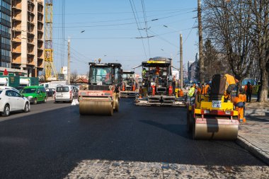 KYIV, UKRAINE - 10 Eylül 2020: Ağır asfalt yol silindirli ağır titreşimli paten sıkıştırıcısı yeni asfalt ve asfalt kaldırıcı makinesini bir sokak inşaatında çalıştırıyor.