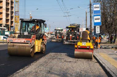 KYIV, UKRAINE - 10 Eylül 2020: Ağır asfalt yol silindirli ağır titreşimli paten sıkıştırıcısı yeni asfalt ve asfalt kaldırıcı makinesini bir sokak inşaatında çalıştırıyor.