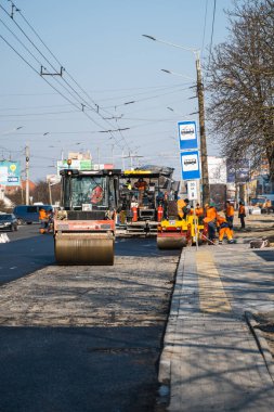 KYIV, UKRAINE - 10 Eylül 2020: Ağır asfalt yol silindirli ağır titreşimli paten sıkıştırıcısı yeni asfalt ve asfalt kaldırıcı makinesini bir sokak inşaatında çalıştırıyor.
