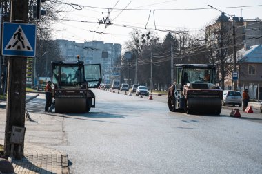 KYIV, UKRAINE - 10 Eylül 2020: Ağır asfalt yol silindirli ağır titreşimli paten sıkıştırıcısı, bir cadde üzerindeki yol inşaatında yeni bir sıcak asfalta baskı yapıyor..