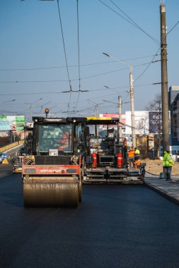 KYIV, UKRAINE - 10 Eylül 2020: Ağır asfalt yol silindirli ağır titreşimli paten sıkıştırıcısı yeni asfalt ve asfalt kaldırıcı makinesini bir sokak inşaatında çalıştırıyor.