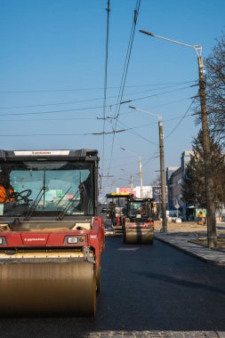 KYIV, UKRAINE - 10 Eylül 2020: Ağır asfalt yol silindirli ağır titreşimli paten sıkıştırıcısı yeni asfalt ve asfalt kaldırıcı makinesini bir sokak inşaatında çalıştırıyor.