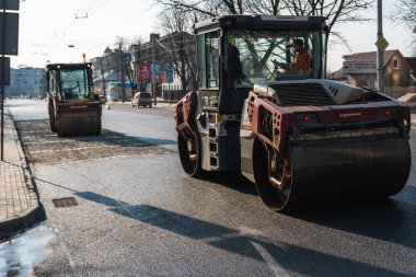 KYIV, UKRAINE - 10 Eylül 2020: Ağır asfalt yol silindirli ağır titreşimli paten sıkıştırıcısı, bir cadde üzerindeki yol inşaatında yeni bir sıcak asfalta baskı yapıyor..