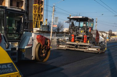 KYIV, UKRAINE - 10 Eylül 2020: Ağır asfalt yol silindirli ağır titreşimli paten sıkıştırıcısı yeni asfalt ve asfalt kaldırıcı makinesini bir sokak inşaatında çalıştırıyor.