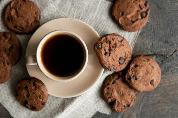Coffee cup with cookies on wooden table background. Mug of black coffee with chocolate cookies. Fresh coffee beans. — Stock Photo, Image