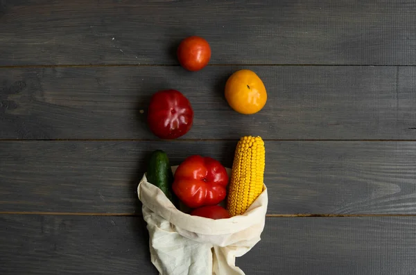Sıfır atık. Biber, domates, mısır, salatalık yeniden kullanılabilir ekolojik çevre dostu pamuk kumaş torbaları. Tahta bir masada sebzeler eko torbanın içinde. Plastiksiz konsept.