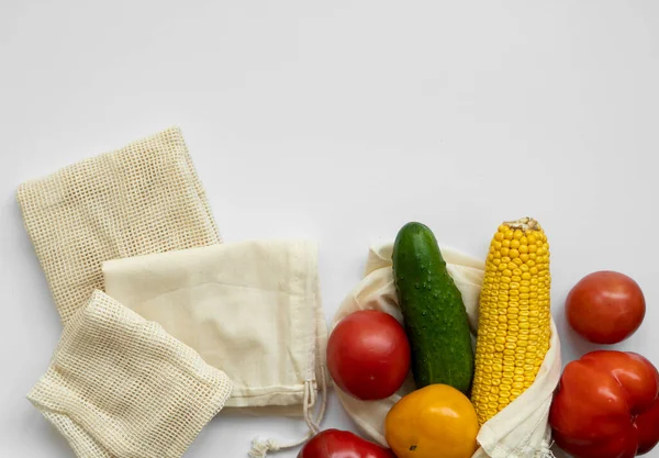 Bunch of mixed organic vegetables and empty reusable cotton bag on a table. Zero waste concept. Eco friendly lifestyle concept. Groceries and eco bags. Plastic free items. Reuse, reduce, recycle. — Stock Photo, Image