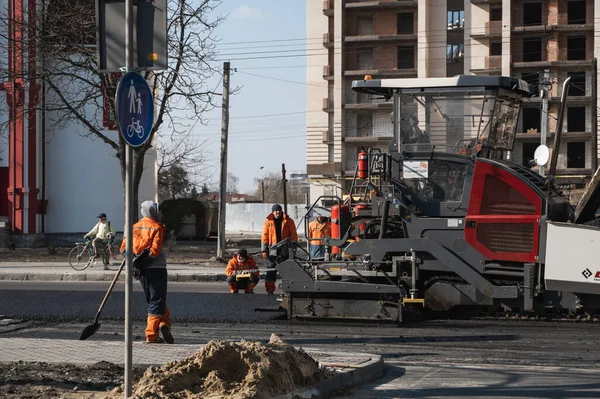 KYIV, UKRAINE - 10 Eylül 2020: Sanayi asfalt kaldırım makinesi sokaktaki yol inşaat sahasına taze asfalt seriyor.