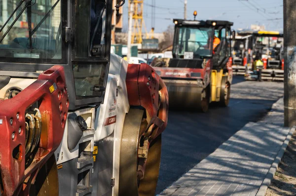 KYIV, UKRAINE - 10 września 2020: Ciężki asfaltowy wałek drogowy z ciężkim zagęszczaczem walców wibracyjnych, który wciska nowy gorący asfalt na jezdni na placu budowy dróg na ulicy. — Zdjęcie stockowe