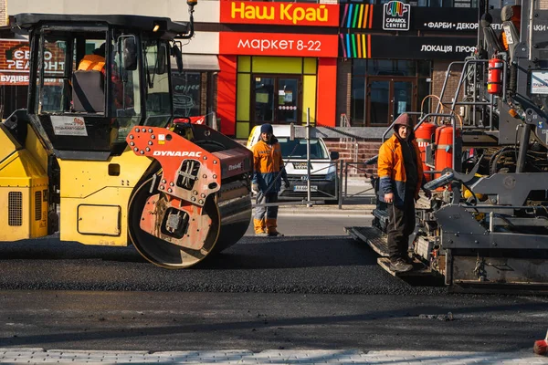 KYIV, UKRAINE - 10 września 2020: Ciężki asfaltowy wałek drogowy z ciężkim zagęszczaczem wibracyjnym, który wciska nowy gorący asfalt i nawierzchnię asfaltową na budowie drogi na ulicy. — Zdjęcie stockowe