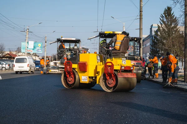 KYIV, UKRAINE - 10 września 2020: Ciężki asfaltowy wałek drogowy z ciężkim zagęszczaczem wibracyjnym, który wciska nowy gorący asfalt i nawierzchnię asfaltową na budowie drogi na ulicy. — Zdjęcie stockowe