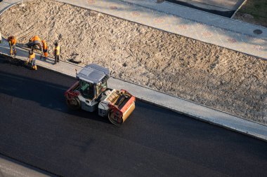 KYIV, UKRAINE - 10 Eylül 2020: Ağır asfalt yol silindirli ağır titreşimli paten sıkıştırıcısı, bir cadde üzerindeki yol inşaatında yeni bir sıcak asfalta baskı yapıyor..