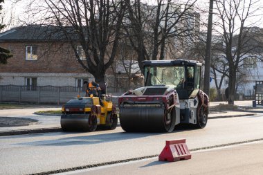 KYIV, UKRAINE - 10 Eylül 2020: Ağır asfalt yol silindirli ağır titreşimli paten sıkıştırıcısı, bir cadde üzerindeki yol inşaatında yeni bir sıcak asfalta baskı yapıyor..