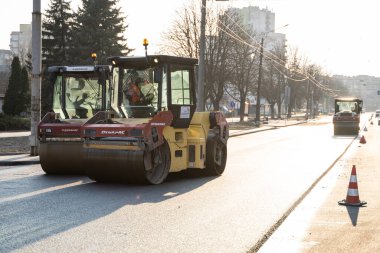 KYIV, UKRAINE - 10 Eylül 2020: Ağır asfalt yol silindirli ağır titreşimli paten sıkıştırıcısı, bir cadde üzerindeki yol inşaatında yeni bir sıcak asfalta baskı yapıyor..