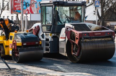 KYIV, UKRAINE - 10 Eylül 2020: Ağır asfalt yol silindirli ağır titreşimli paten sıkıştırıcısı, bir cadde üzerindeki yol inşaatında yeni bir sıcak asfalta baskı yapıyor..